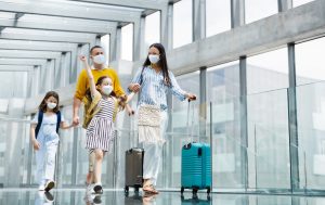 Family,With,Two,Children,Going,On,Holiday,,Wearing,Face,Masks